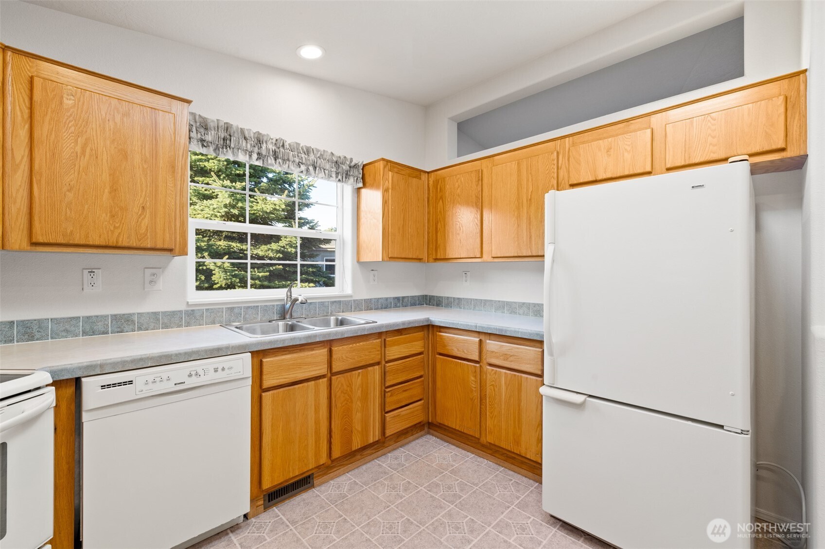 507 North 7th Avenue Sequim, WA 98382 - Photo 9 of 40 a kitchen with a refrigerator sink and cabinets