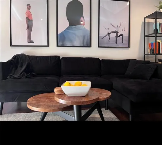 a living room with furniture and a painting on the wall