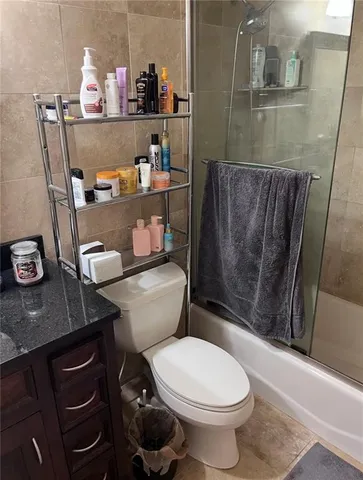 a bathroom with a granite countertop toilet and a sink