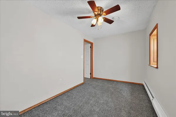 an empty room with a window and a ceiling fan