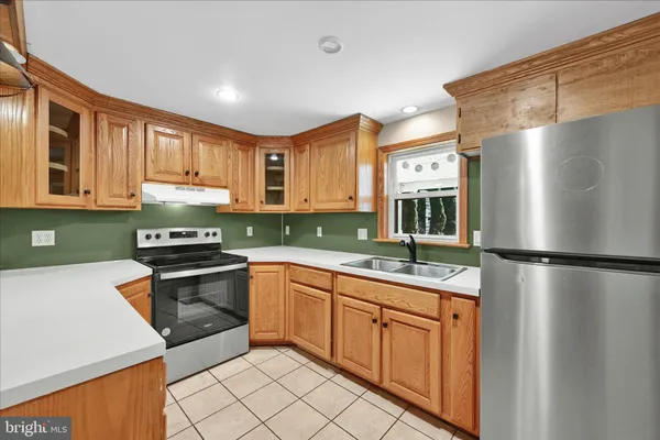 a kitchen with stainless steel appliances granite countertop a refrigerator sink and stove