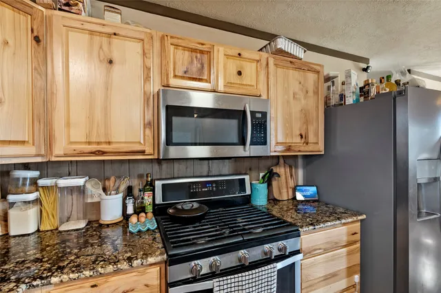 a kitchen with stainless steel appliances granite countertop a stove and a microwave
