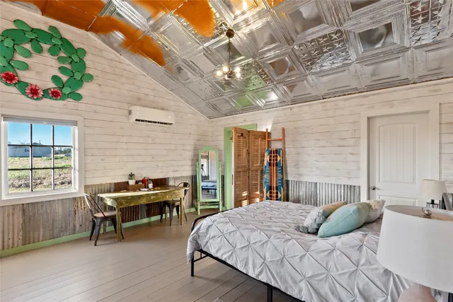 a spacious bedroom with furniture and a large window