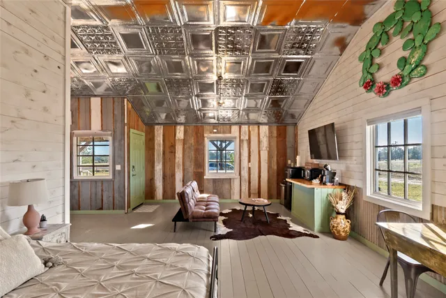 a bedroom with a bed a television and a desk