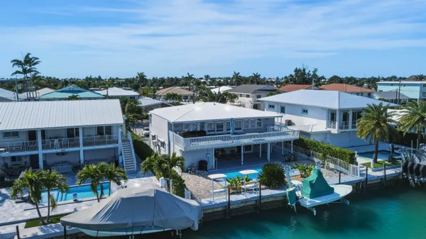 a front view of a house with a garden and lake view