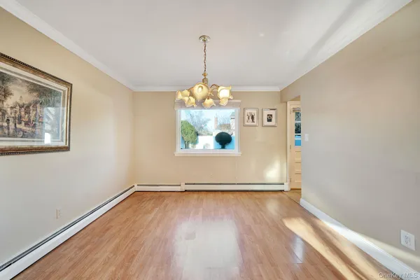 a view of a room with wooden floor chandelier and a window