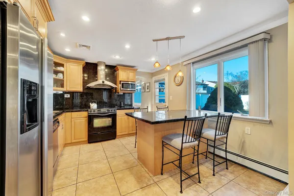 a kitchen with stainless steel appliances granite countertop wooden cabinets and a refrigerator