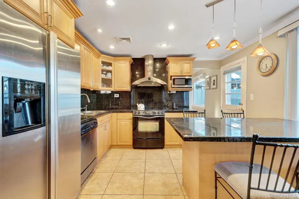 a kitchen with stainless steel appliances granite countertop a refrigerator a oven and a sink