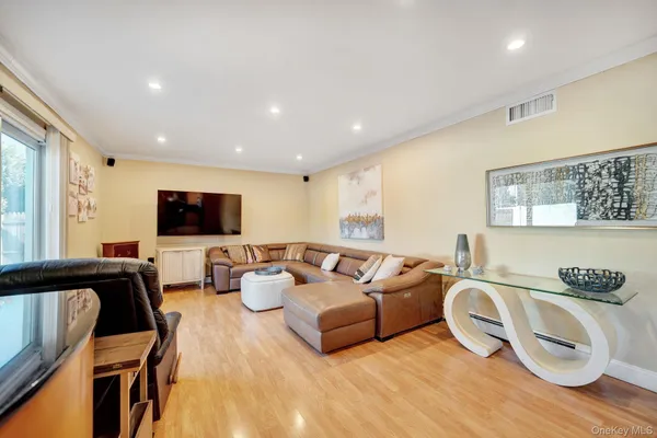 a living room with furniture a flat screen tv and a window
