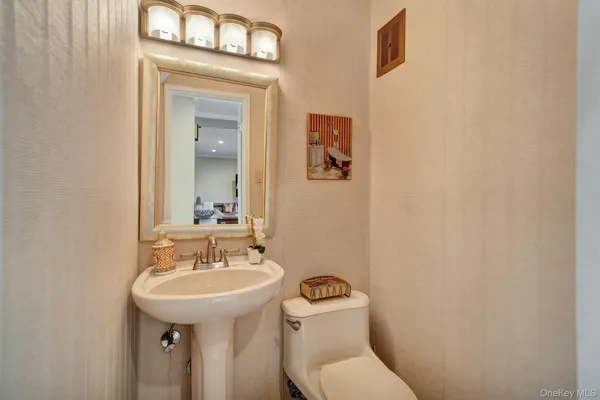 a bathroom with a toilet sink and mirror