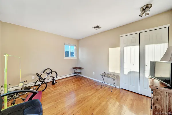 a room with gym equipment and wooden floor