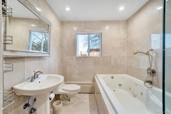 a bathroom with a bathtub a sink and mirror