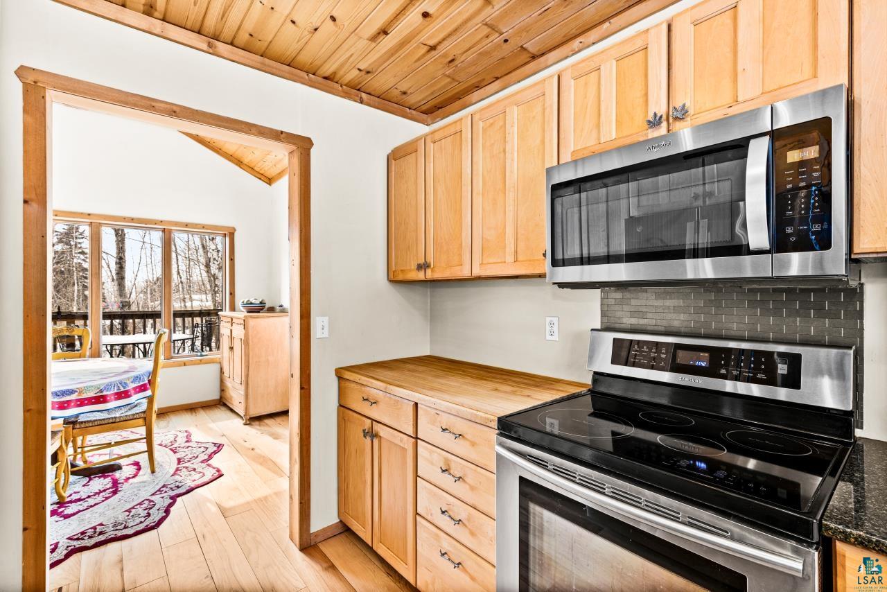 67 Snowshoe Trail Tofte, MN 55615 - Photo 25 of 42 Kitchen featuring stainless steel appliances, a vaulted wooden ceiling, light wood finish cabinets, light wood-style floors, and wooden counters