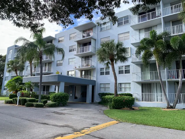 a front view of a residential houses with yard and green space