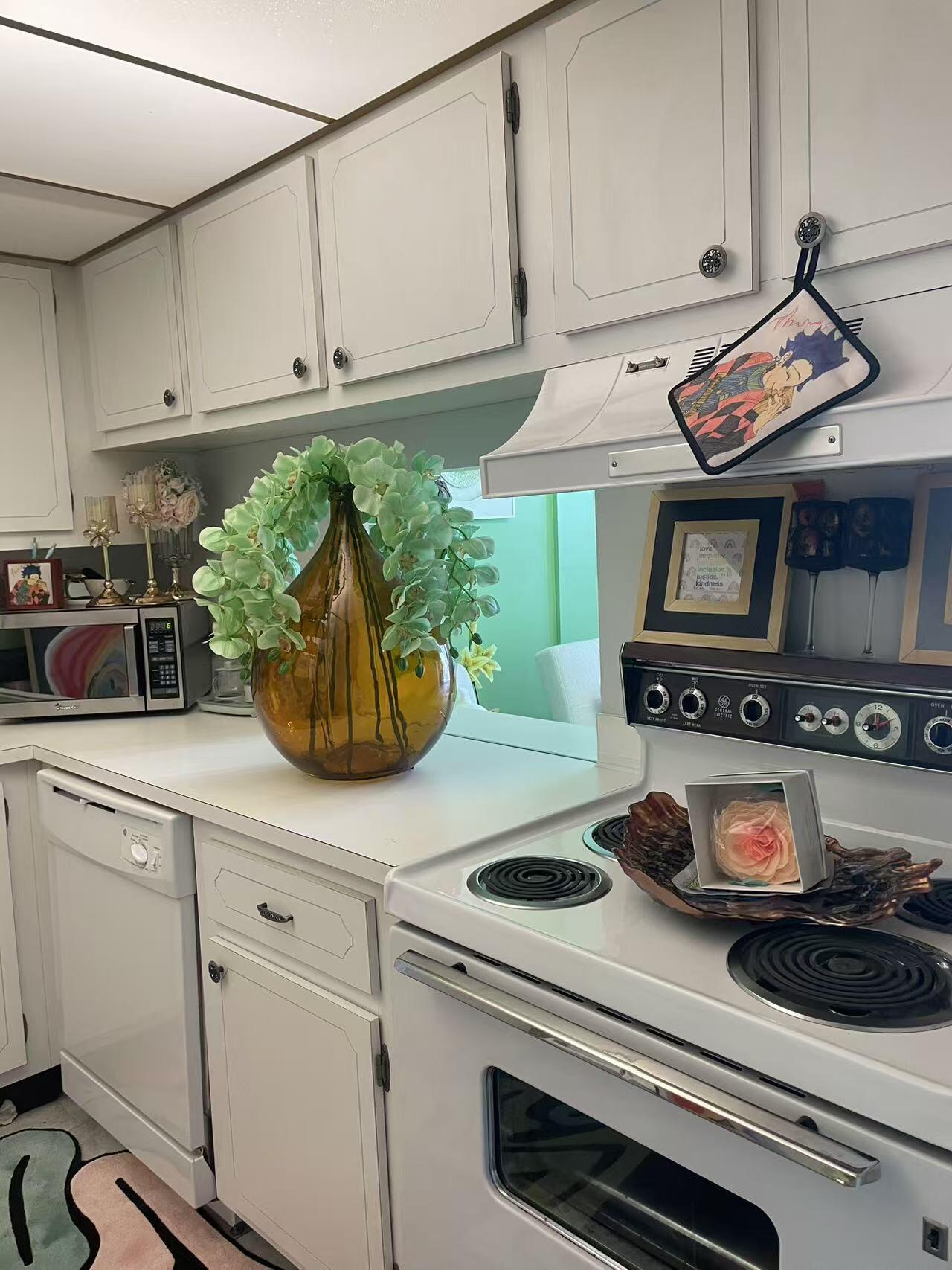 500 Executive Center Drive, Unit 3F West Palm Beach, FL 33401 - Photo 13 of 20 a kitchen with stainless steel appliances granite countertop a stove and white cabinets
