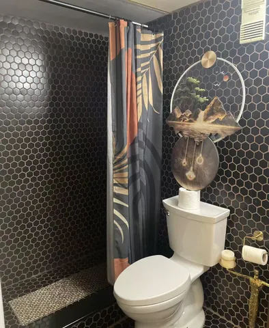 a bathroom with a toilet and a shower