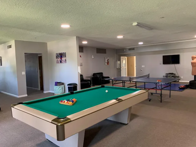 a room with pool table and windows