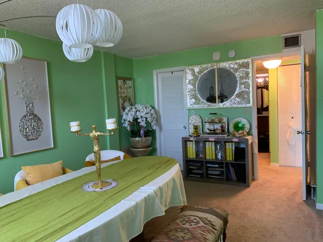 a room with kitchen island stainless steel appliances furniture and a chandelier