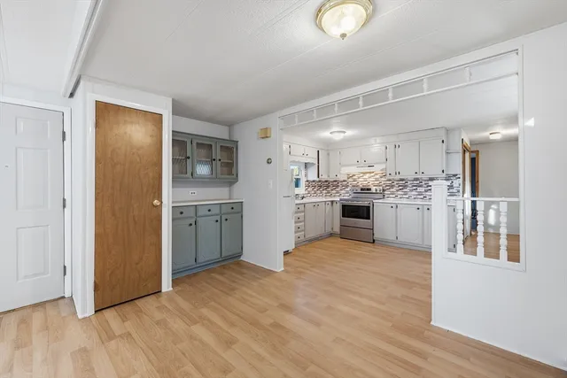a view of kitchen with kitchen island wooden floor center island and stainless steel appliances