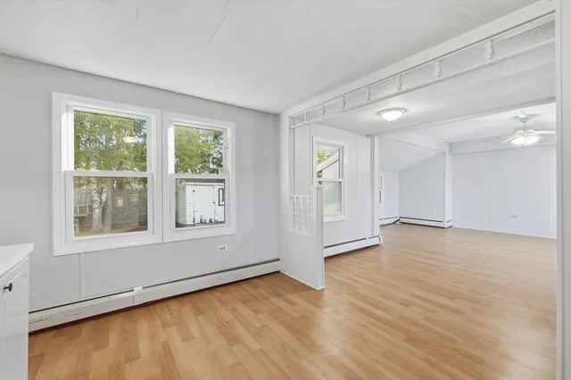 an empty room with wooden floor and windows