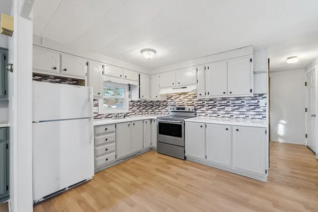 a kitchen with white cabinets and white appliances