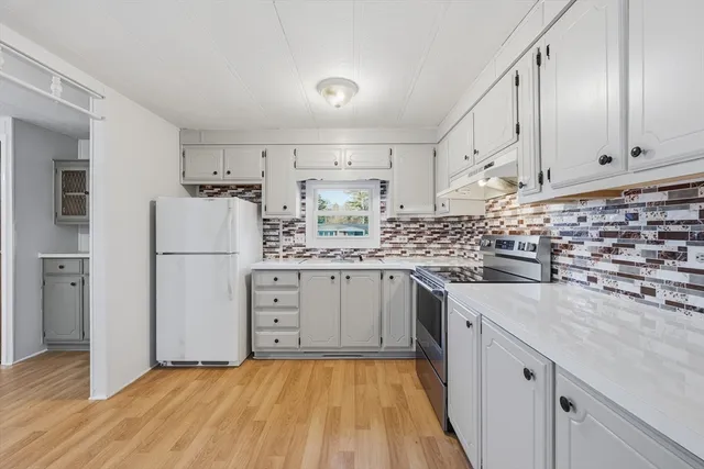 a kitchen with white cabinets and white appliances