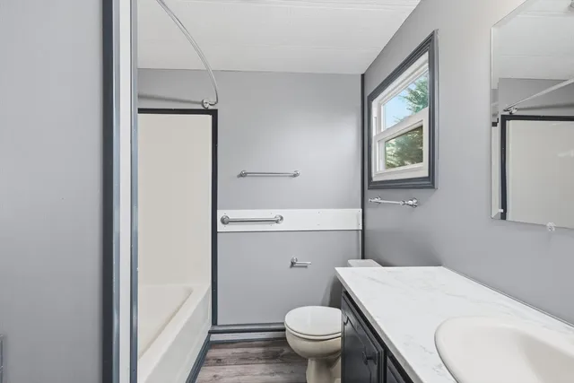 a bathroom with a granite countertop toilet and a sink