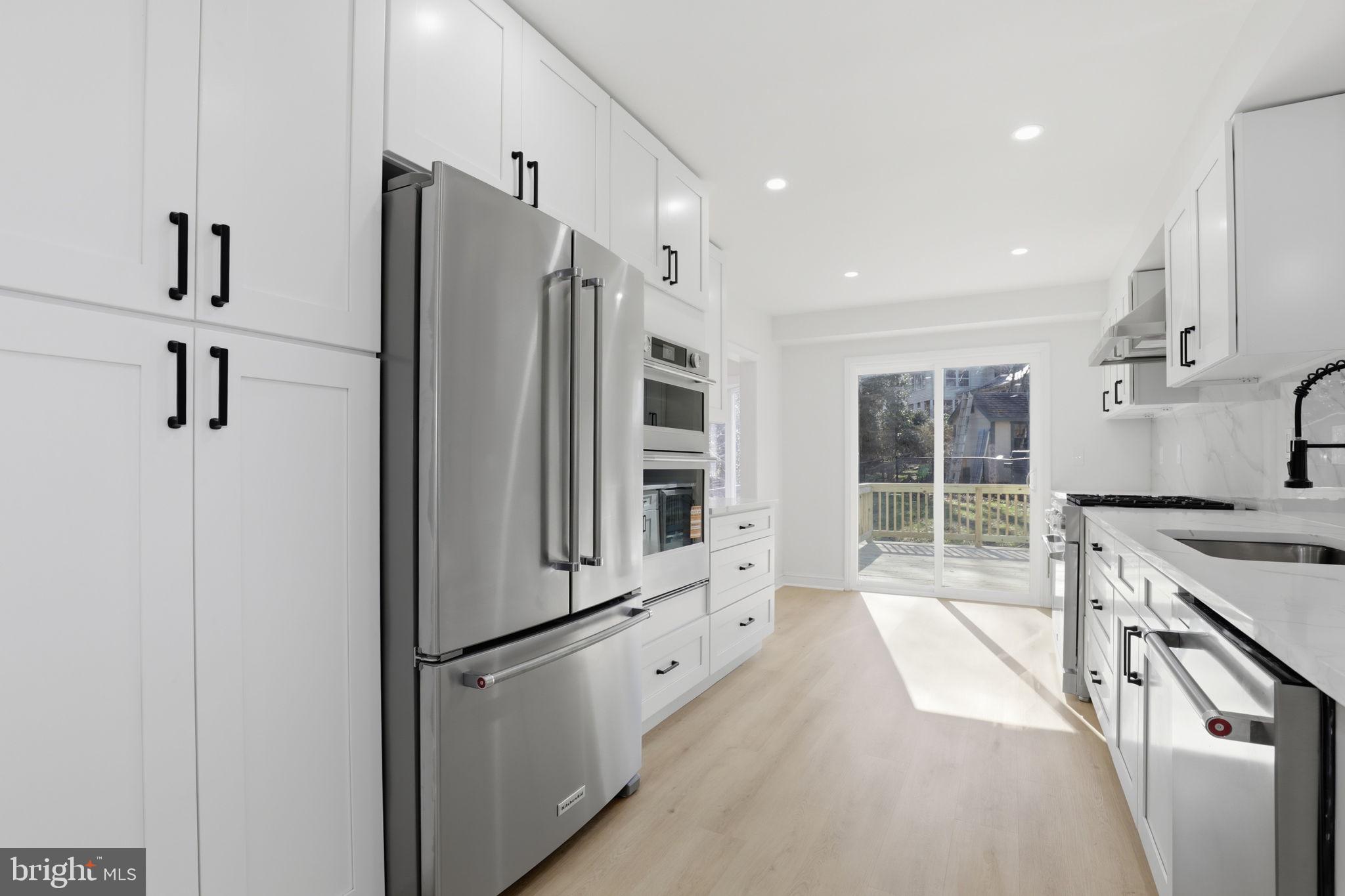 311 Ellsworth Drive Silver Spring, MD 20910 - Photo 14 of 60 a kitchen with stainless steel appliances a refrigerator sink and cabinets