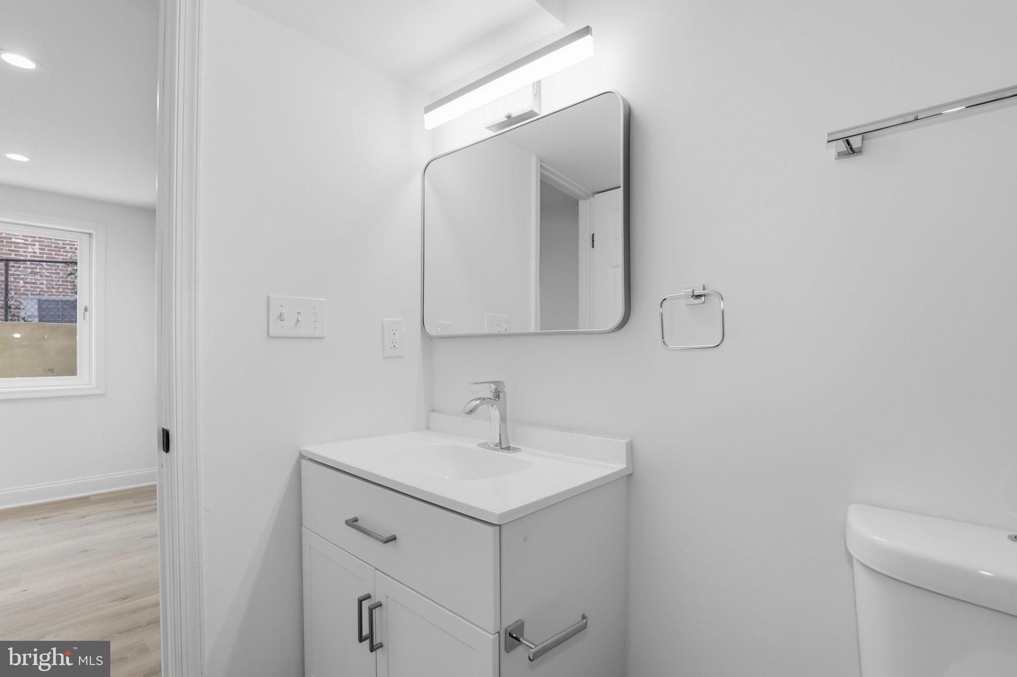311 Ellsworth Drive Silver Spring, MD 20910 - Photo 54 of 60 a bathroom with a toilet sink and mirror
