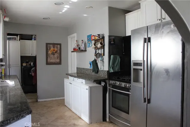 a kitchen with stainless steel appliances granite countertop a refrigerator and a stove