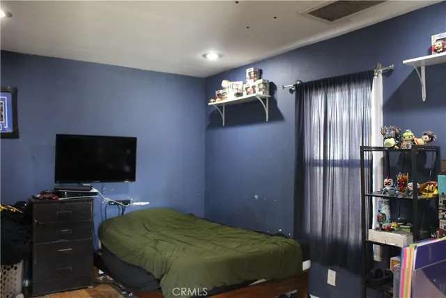 a bedroom with a bed and flat screen tv
