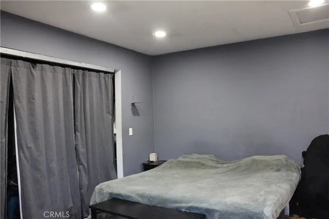 a bed sitting in a room next to a cabinet