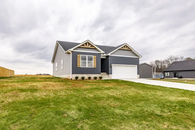 a view of a house with a big yard and large trees