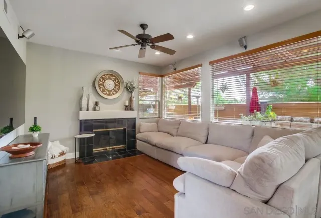 a living room with furniture a fireplace and a large window