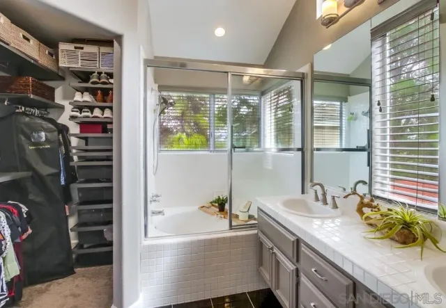 a bathroom with a granite countertop sink a bathtub and shower