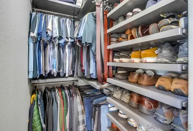 a view of walk in closet with clothes and shoes
