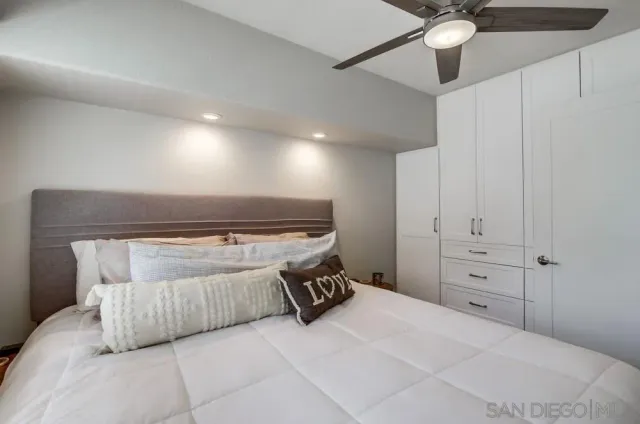 a bedroom with a bed and a ceiling fan