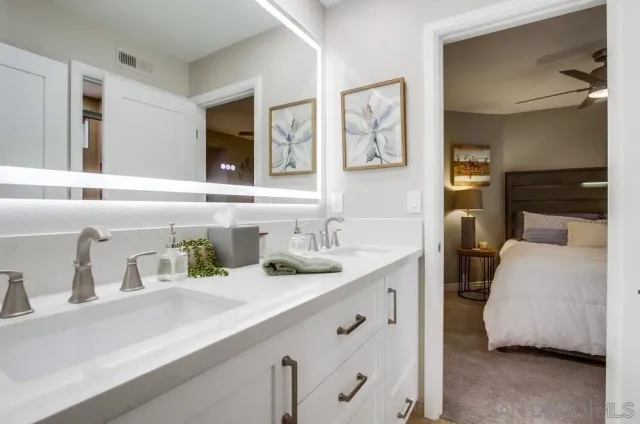 a en suite bathroom with double vanity and a sink