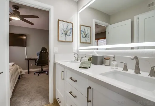 a en suite bathroom with a double vanity sink and a mirror