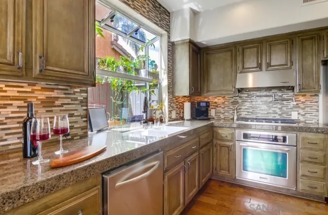 a kitchen with stainless steel appliances granite countertop a sink and a stove
