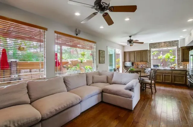 a living room with furniture kitchen area and a large window