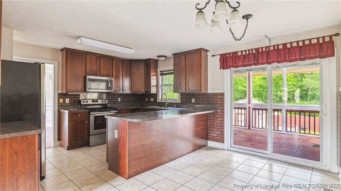 106 Linden Road Cameron, NC 28326 - Photo 12 of 48 a kitchen with stainless steel appliances granite countertop a stove a sink dishwasher a refrigerator and a microwave oven with cabinets