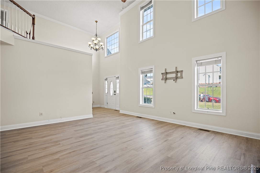 106 Linden Road Cameron, NC 28326 - Photo 4 of 48 an empty room with wooden floor chandelier and windows