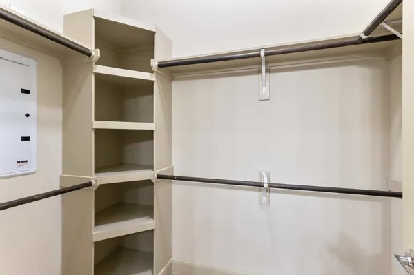a view of walk in closet with empty racks