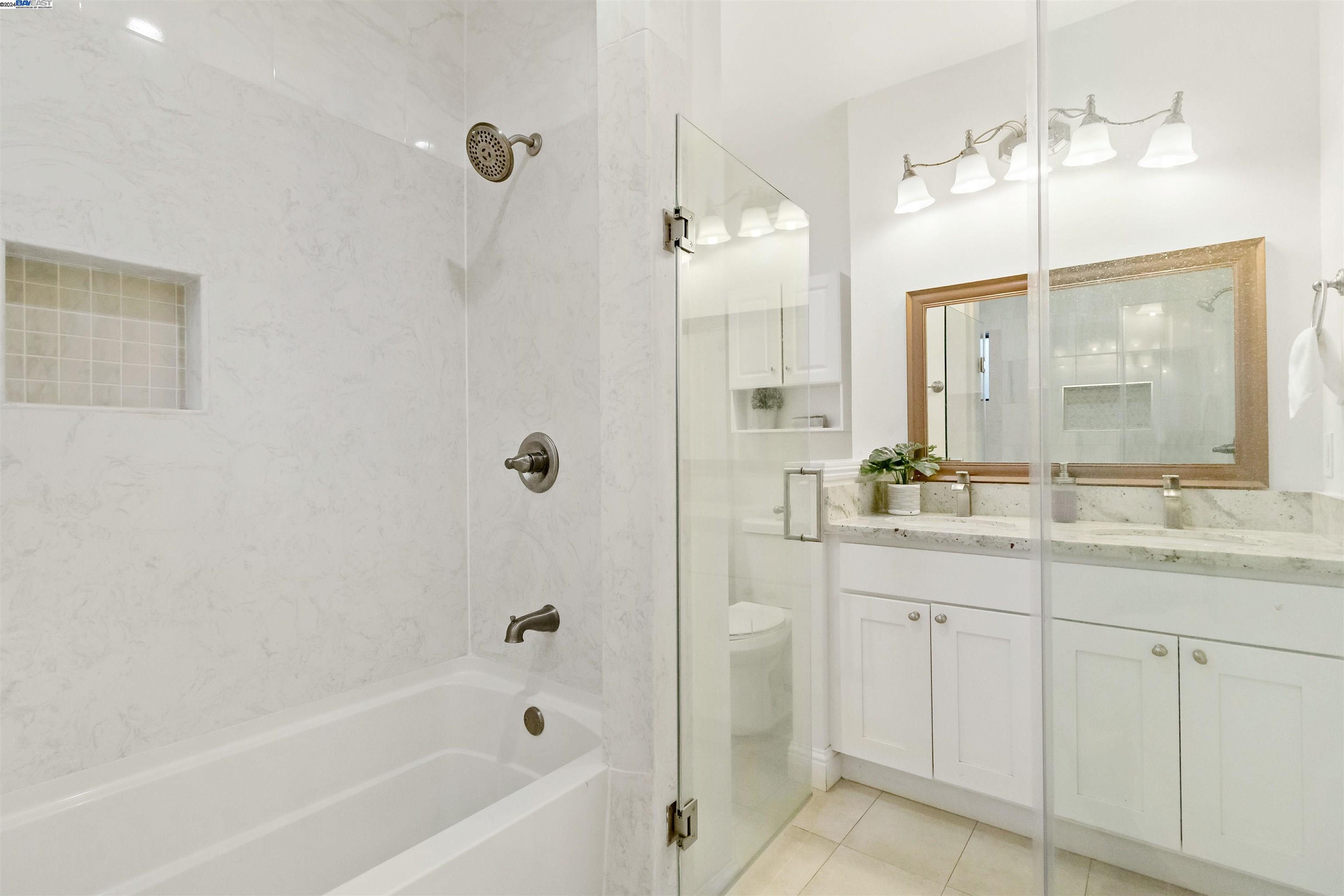 Warm Springs Fremont, CA 94539 - Photo 17 of 27 a bathroom with a granite countertop sink a mirror a shower and a bathtub