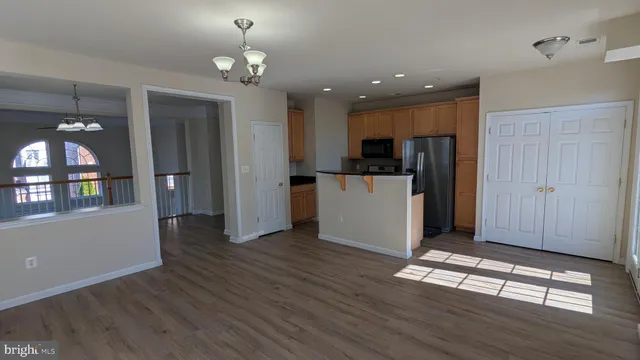 a view of a kitchen with a sink a refrigerator and wooden floor