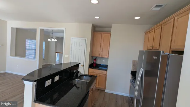 a kitchen with granite countertop a refrigerator stove and microwave