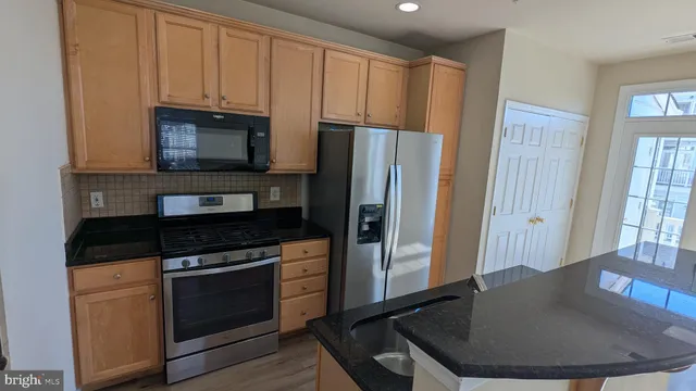 a view of a kitchen with wooden floor and a refrigerator