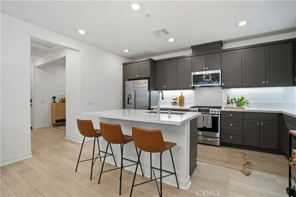 a kitchen with stainless steel appliances a sink a stove a refrigerator and cabinets