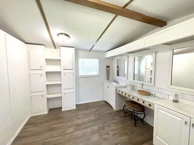 a large white kitchen with a sink stainless steel appliances and cabinets